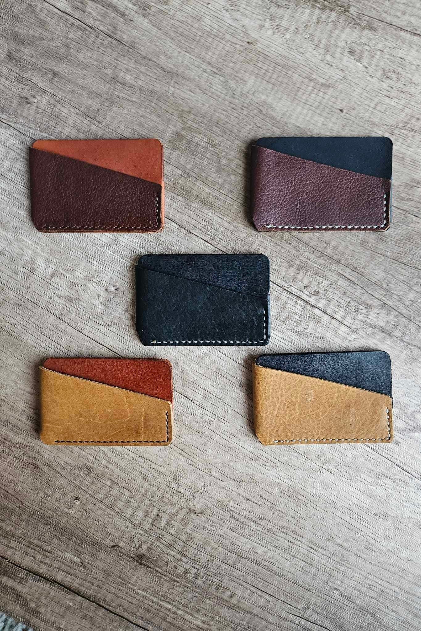 Four slim leather wrap wallets with maroon, black, tan, and blue exteriors