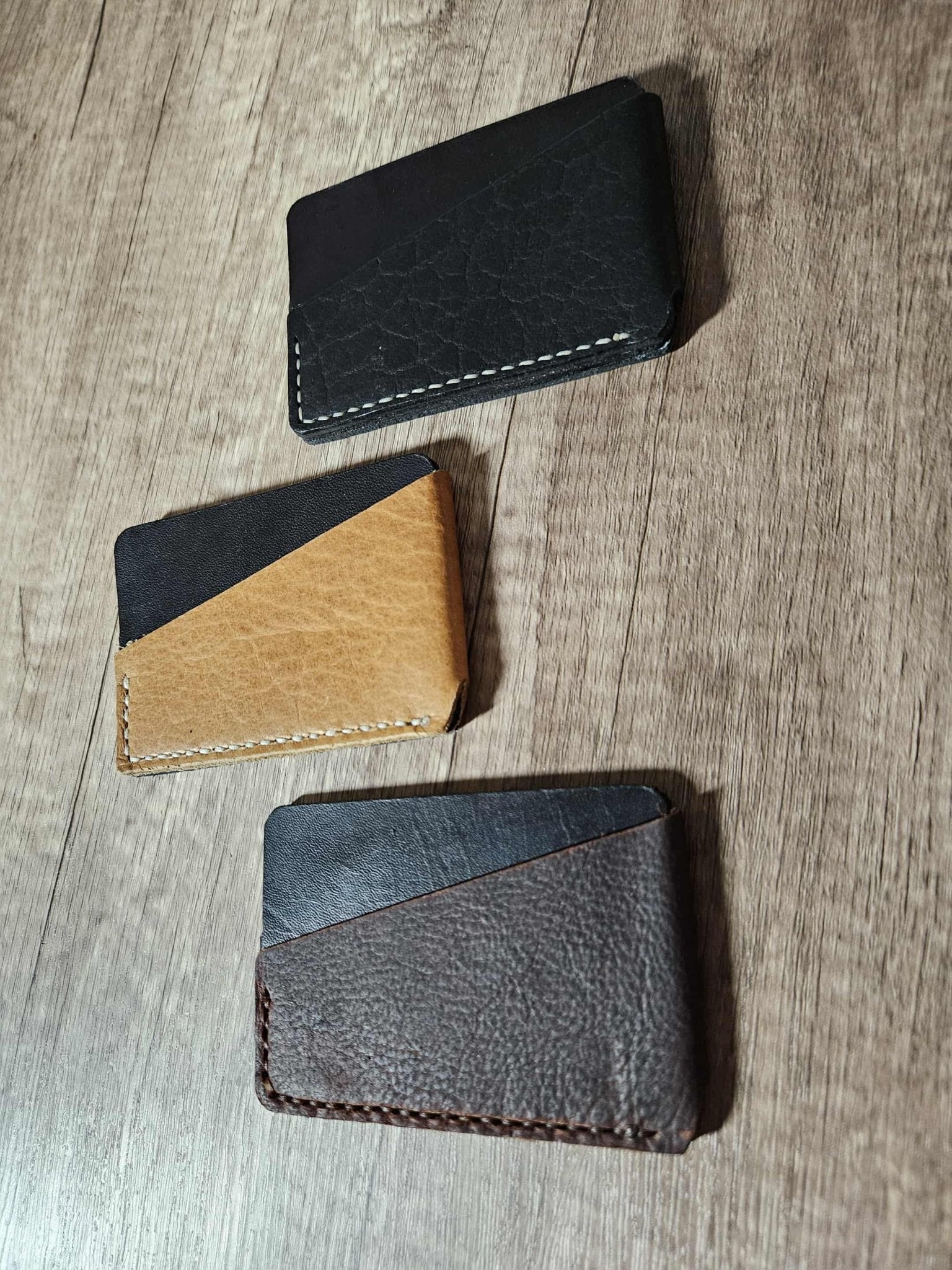 Slim leather wrap wallets in black, tan, and gray with stitched edges