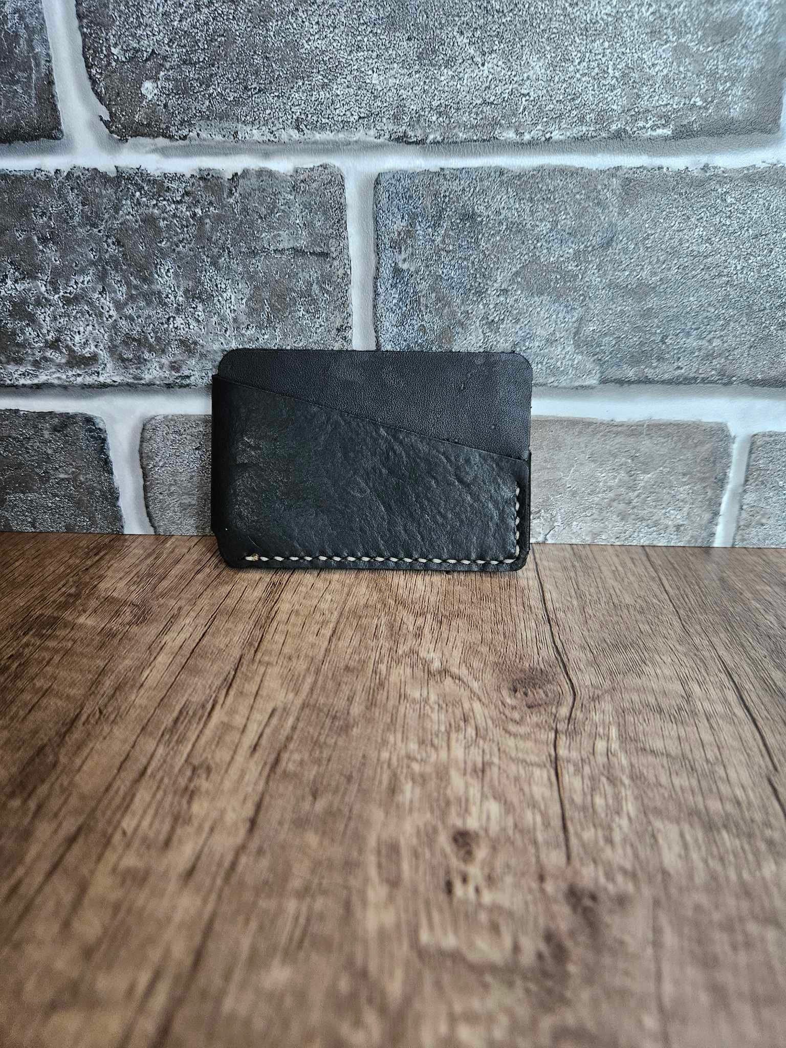 Black leather wrap wallet with stitched edge and top wrap flap