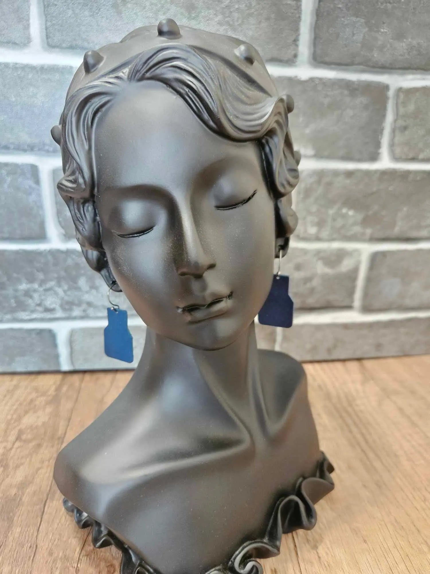 Blue geometric leather drop earrings with dot pattern and silver hooks worn
