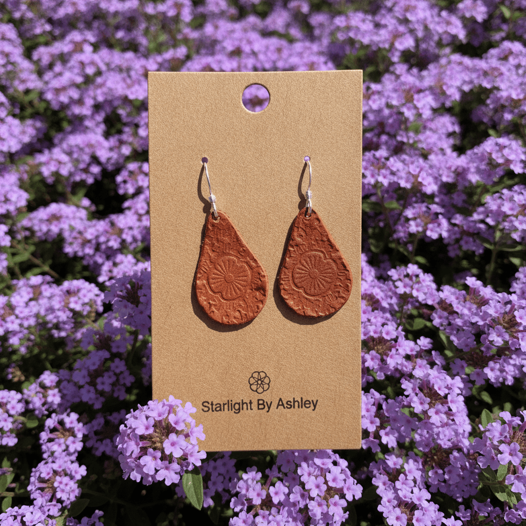 Brown leather teardrop drop earrings with embossed floral design