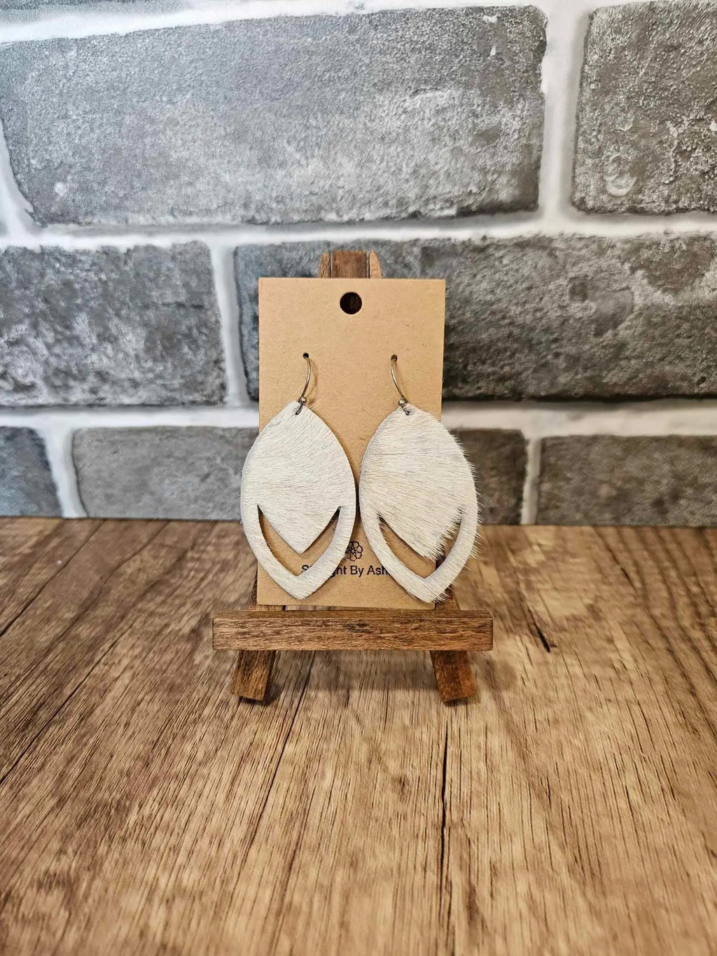 Pair of hair-on-hide leather teardrop earrings with tan fur and curved edges