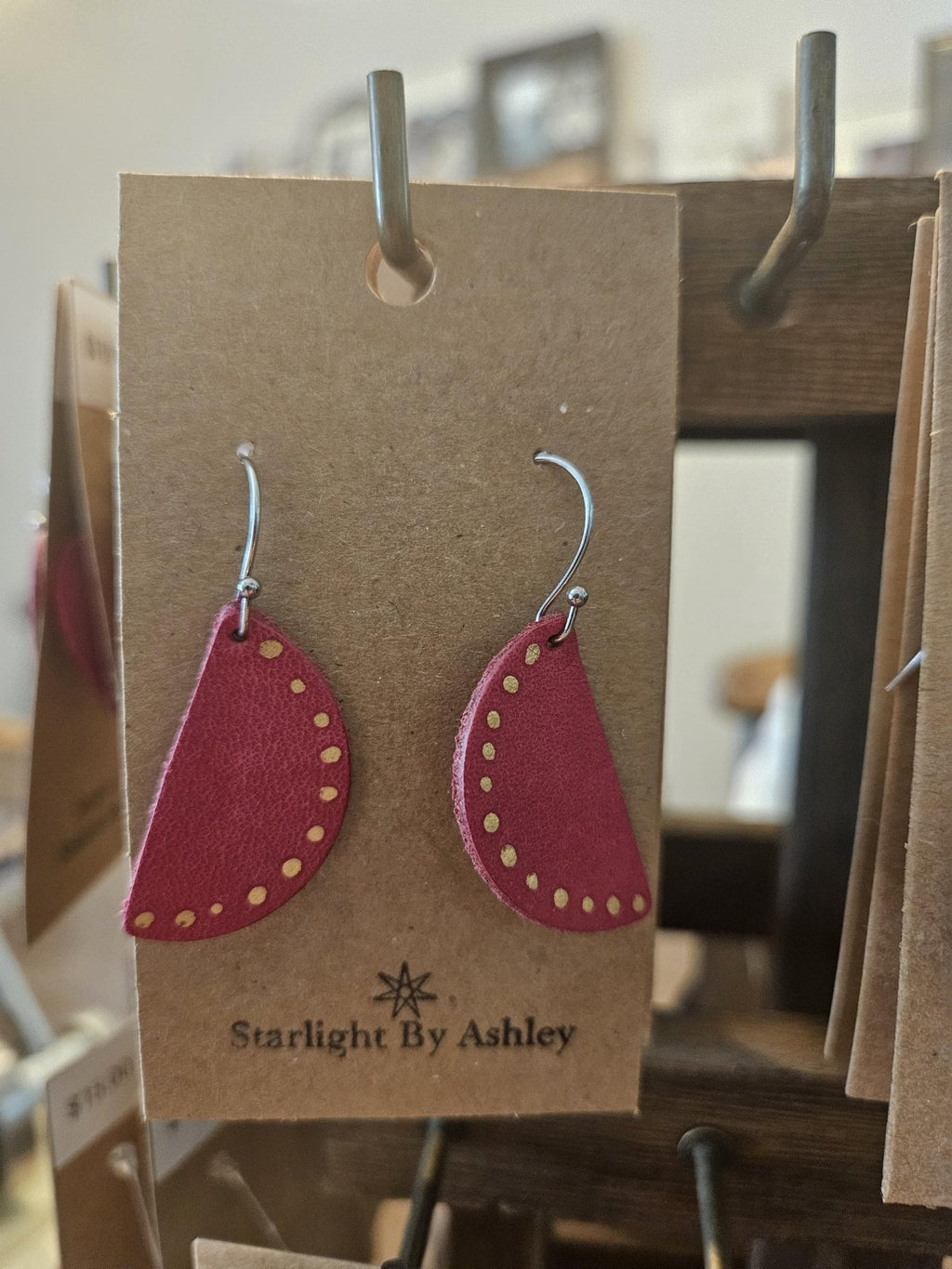 Red half-circle leather earrings with yellow-studded edge on silver fishhooks