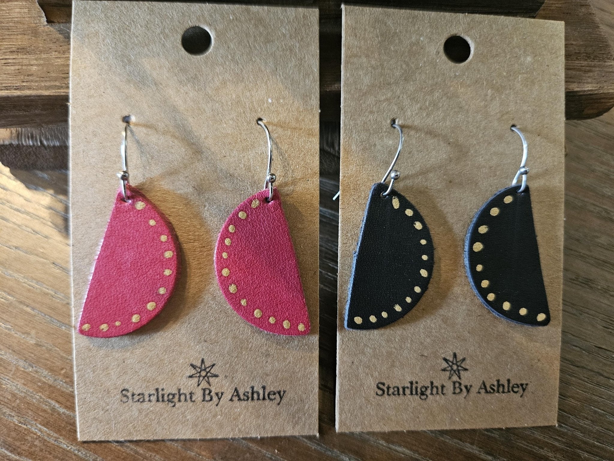 Red half-circle leather earrings with yellow-studded edge and silver hooks