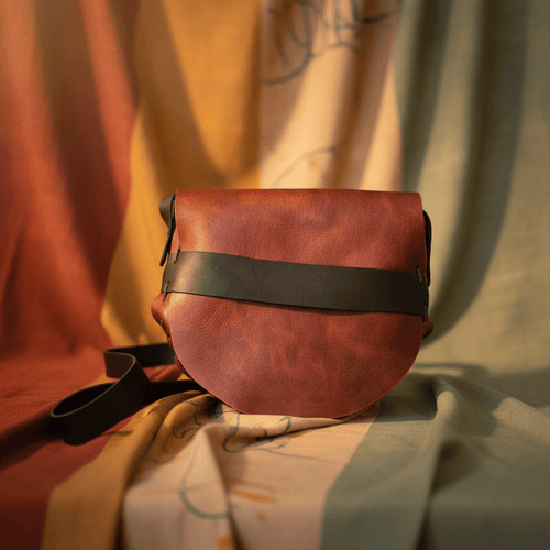 Handmade red leather crossbody purse with curved flap and black adjustable strap