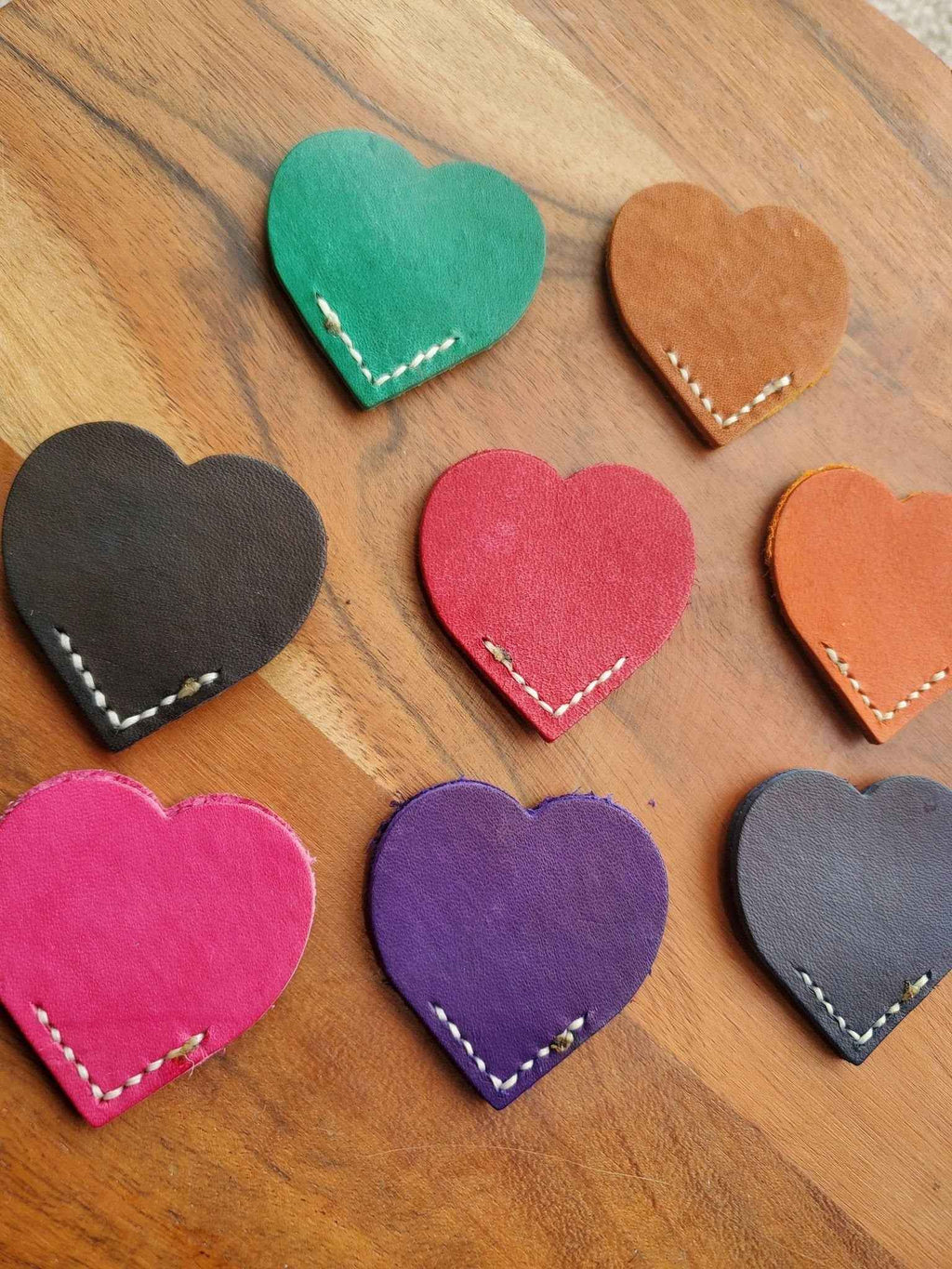Colorful heart leather bookmarks with white stitching, including teal, pink, purple, orange