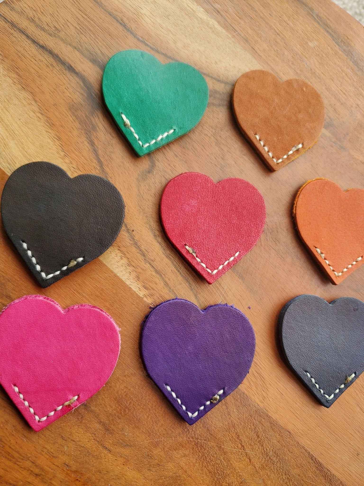 Colorful heart leather bookmarks with white stitching, including teal, pink, purple, orange