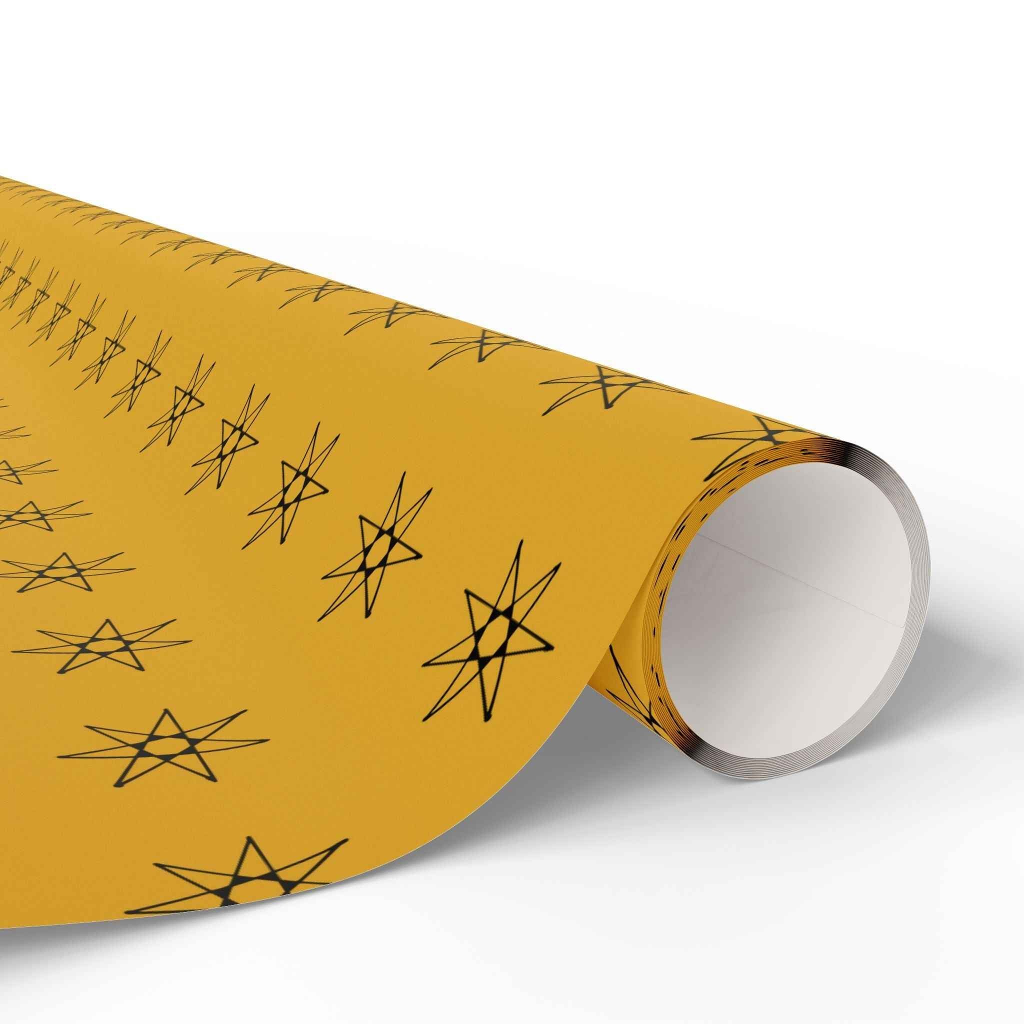 Yellow wrapping paper roll with black seven-point stars, rolled cylinder end close-up