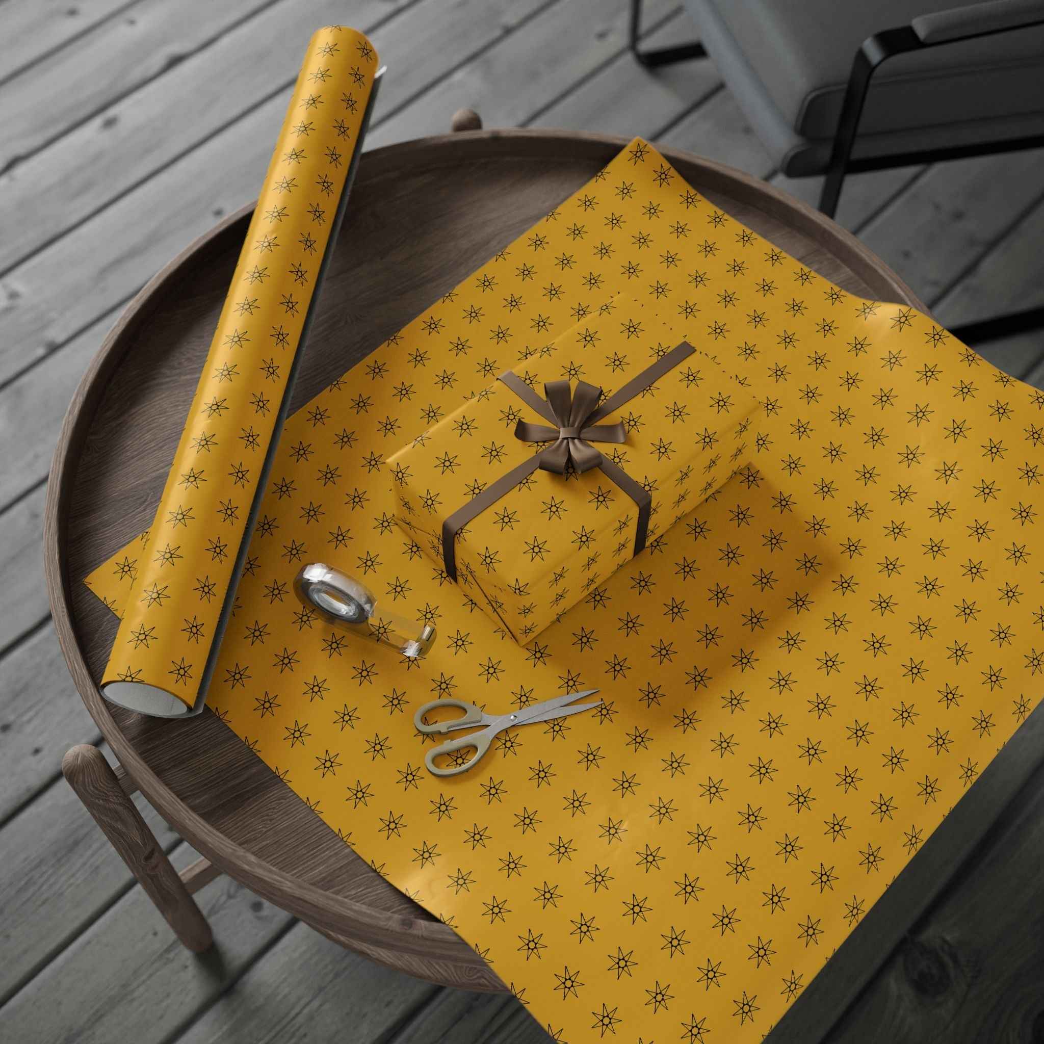 Yellow wrapping paper roll with seven-point star pattern, gift wrap arranged on tray