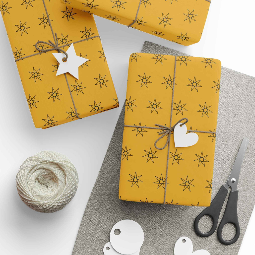 Yellow seven-point star wrapping paper, wrapped gifts with white tags and scissors nearby