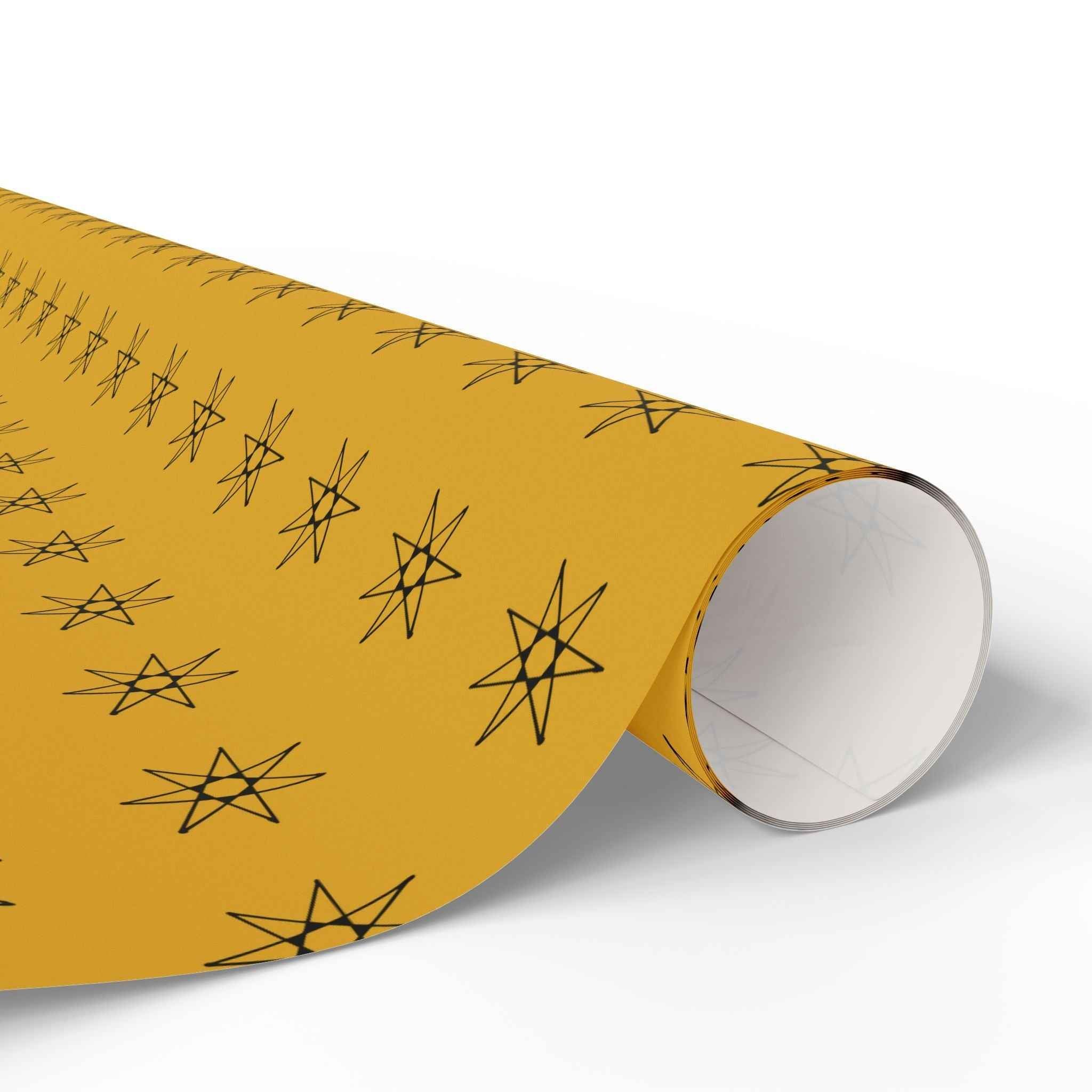 Yellow star wrapping paper roll with black star motif and visible inner tube, close-up end